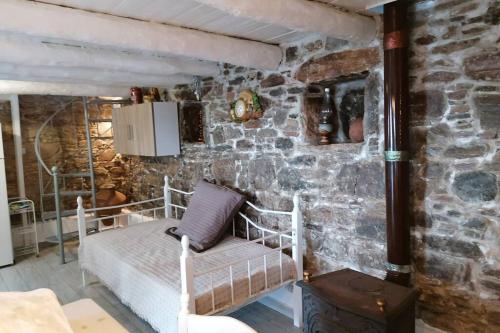 um quarto com duas camas numa parede de pedra em Velanidies Traditional Ikarian House em Xilosírtis