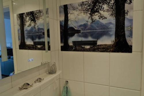 duas fotos de árvores e um banco numa casa de banho em Modernes Apartment mit Traumhaftem Blick ins Grüne em Bräunlingen