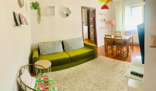 - un salon avec un canapé vert et une table dans l'établissement Modern place to Stay-self check-in nonstop 24h-wifi, à Reşiţa