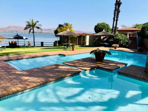 a swimming pool with a view of the water at Kosmos, Hartbeespoort in Hartbeespoort