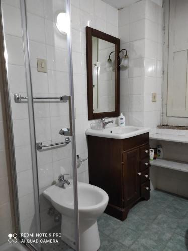 a bathroom with a sink and a toilet and a mirror at CASA SIRENETTA-Little Mermaid House in Lentini