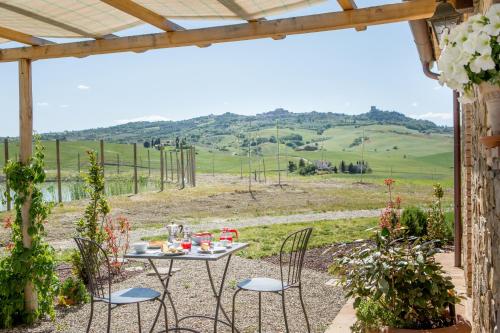 a table and chairs with a view of a field at Agriturismo San Marcello in Castiglione dʼOrcia