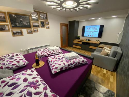 a living room with two beds and a tv at Luxury Apartments Ostrava in Ostrava