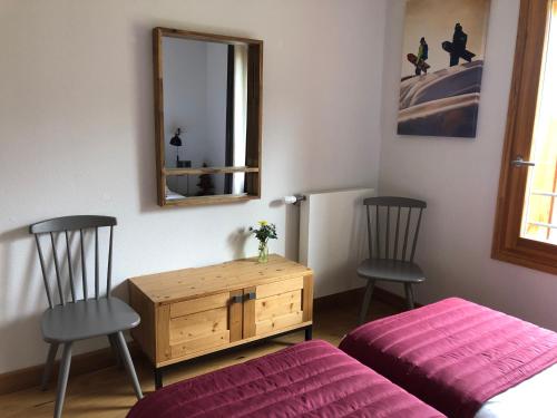 a bedroom with two chairs and a table and a mirror at Luxury 2 Bedroom Apartment with view of Mont Blanc in Combloux