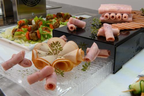 a buffet of food with hot dogs and vegetables at Olympion Village in Kavos