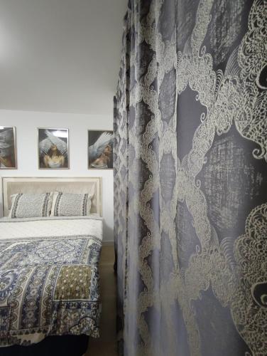 a bedroom with a bed and a curtain at Skyline by Nights & Smiles in Tuzla