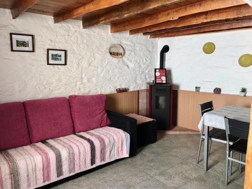 ein Wohnzimmer mit einem Sofa und einem Tisch in der Unterkunft Thistle Cottage Alojamento Local in Gatas