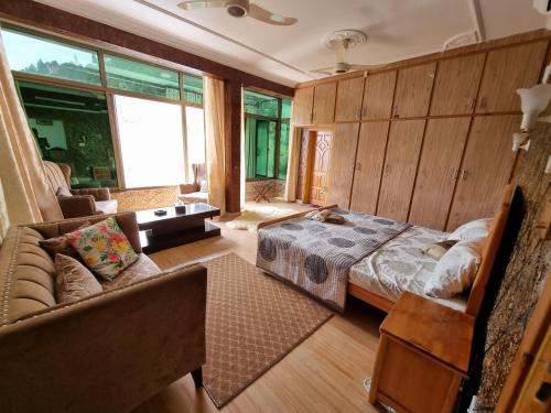 sypialnia z łóżkiem i kanapą w pokoju w obiekcie Srinagar Homes w mieście Muzaffarabad