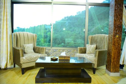 a living room with two chairs and a coffee table at Srinagar Homes in Muzaffarabad