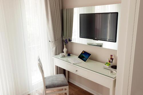 Habitación con escritorio, ordenador portátil y TV. en Ten Rooms Istanbul Hotel en Estambul