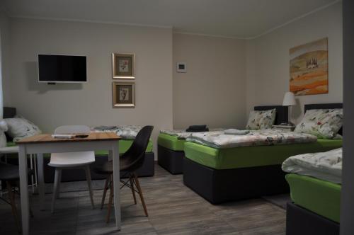a hotel room with two beds and a table and a desk at Ferienwohnungen Margot in Iserlohn