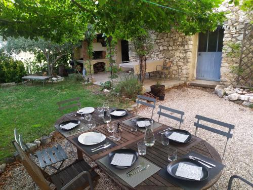 a wooden table and chairs in a yard with a table and chairsktop at Chambre d'hôtes face au lavoir in Méthamis