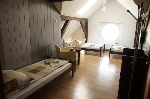 um quarto com duas camas e cadeiras e uma janela em Pałacyk w Pakości Hotel em Pakość