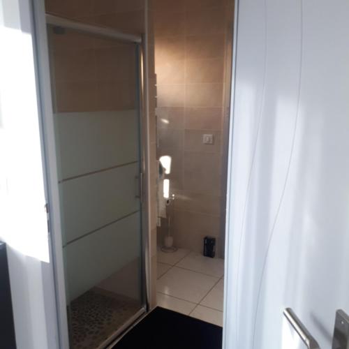 une salle de bain avec une douche avec une porte vitrée dans l'établissement La Casa Tranquilia chez Véro et JJ Studio à Marseillan, à Marseillan