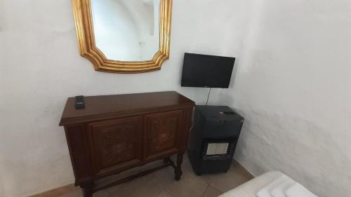 Habitación con espejo y tocador con TV. en Trullo Alberobello Vacanze Desà 2, en Alberobello