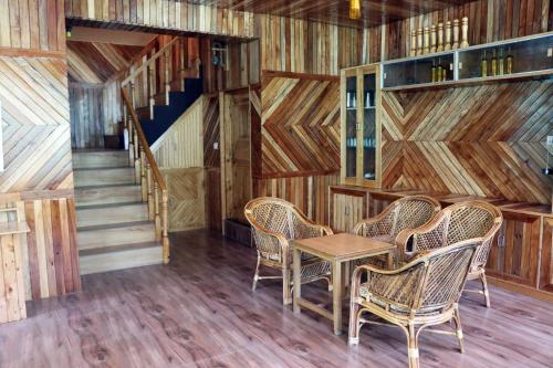a room with a table and chairs and a staircase at The Himalayan Heaven in Jibhi