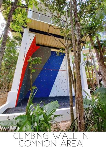 a climbing wall in ailion area with a tree at Casa Kuaan Mani TH 1 in Tulum