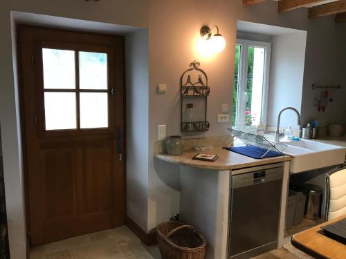 a kitchen with a counter and a sink and a door at LA GRANGE in Saint-Prix-lès-Arnay