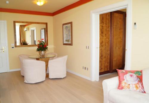 a living room with a table and white chairs at Hotel Greif in Lignano Sabbiadoro