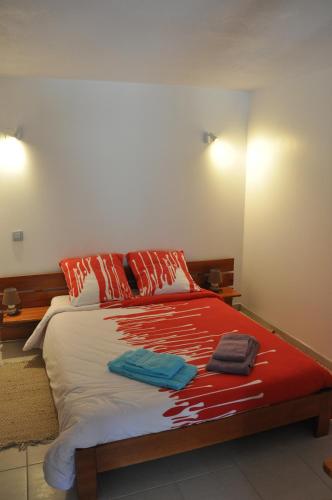 um quarto com uma cama com lençóis vermelhos e brancos em La Bourgeat em Chantesse