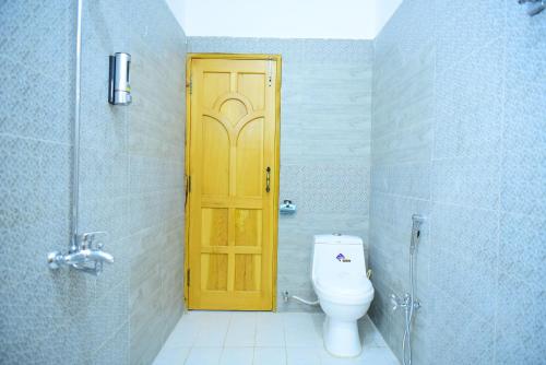 a bathroom with a toilet and a yellow door at Srinagar Homes in Muzaffarabad