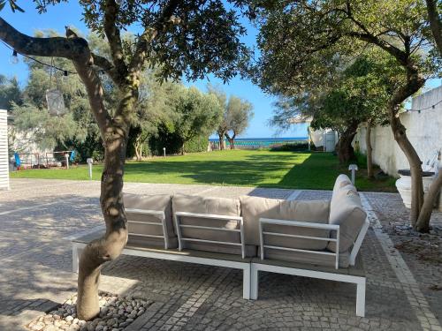 a white couch sitting next to a tree at Villa degli Squali Suite Home in Terracina