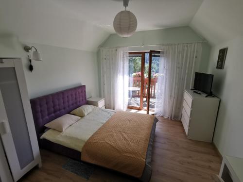シフィエラドゥフ・ズドルイにあるStrefa Ciszy -Lawendaのベッドルーム(紫色のベッド1台、テレビ付)