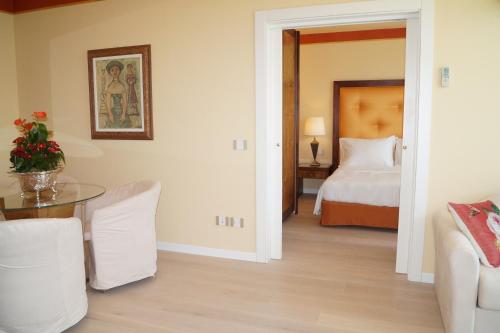 a room with a bedroom with a bed and a table at Hotel Greif in Lignano Sabbiadoro