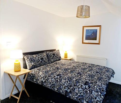 a bedroom with a bed and two lamps on tables at Cosy little cottage in Deiniolen near Llanberis in Caernarfon