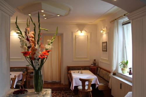a restaurant with a vase of flowers on a table at Romantic-Pension Albrecht - Villa next to UNESCO World Heritage - since 1901 in Hohenschwangau