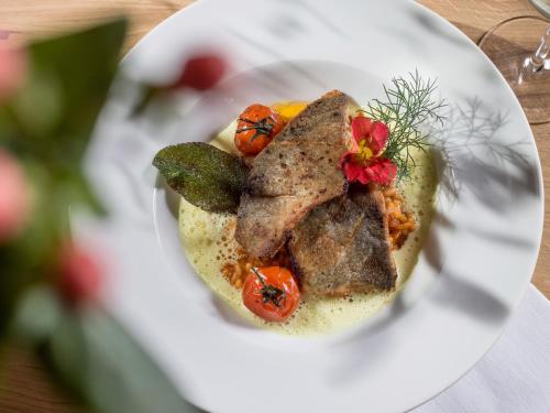a plate of food with meat and vegetables on a table at Hotel - Gasthof Märzenklamm in Stumm
