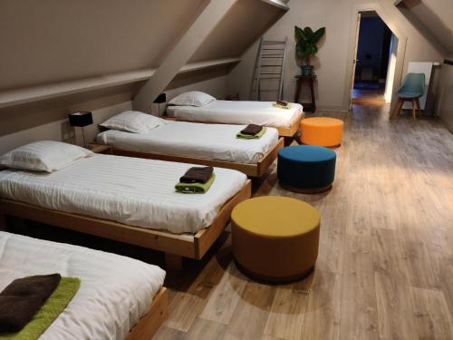 ブラーケルにあるFlandrien Hotelのベッド3台、テーブル、椅子が備わる客室です。