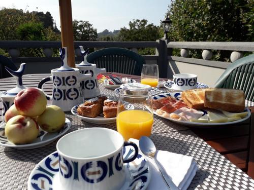 une table avec des assiettes de nourriture et des tasses de jus d'orange dans l'établissement Casa Estarque, à Gondomar