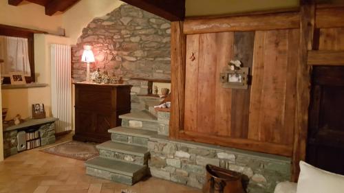 a living room with a stone wall and stairs at HOME SWEET HOME in Antey-Saint-André