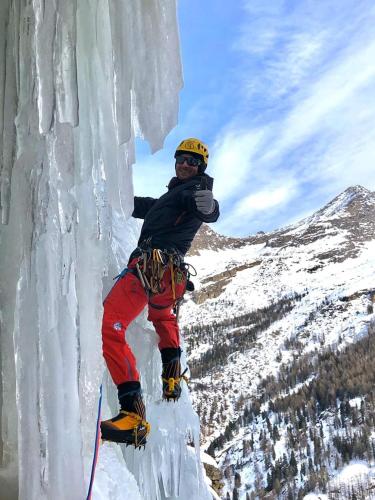 a person is standing on the side of a ice wall at HOME SWEET HOME in Antey-Saint-André