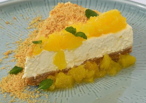a piece of pineapple cheesecake on a blue plate at Porto Veneziano Hotel in Chania Town