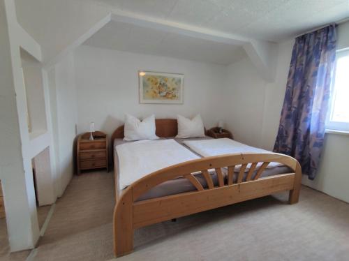 een slaapkamer met een groot bed met een houten frame bij Sirisferienhaus in Kurort Steinbach-Hallenberg
