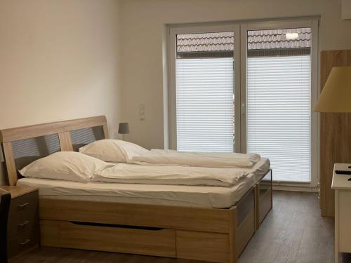 a bed in a bedroom with two windows at Stilvoll Wohnen in Oldenburg Kreyenbrück Apartments in Oldenburg