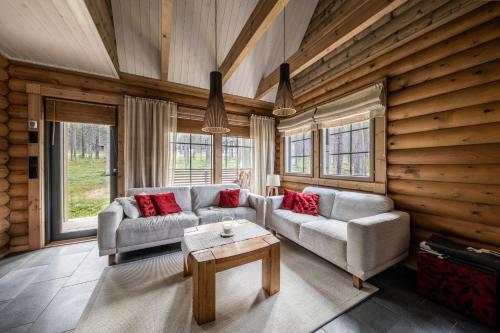 a living room with two couches and a table at Hullun Mustikka Levi in Levi