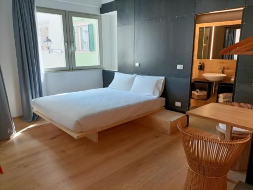 a bedroom with a large bed and a table at Le Meridiane City Rooms In Trento in Trento
