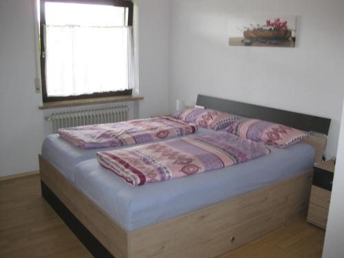 a bedroom with a bed with pink sheets and a window at Haus Weißbrod in Essingen