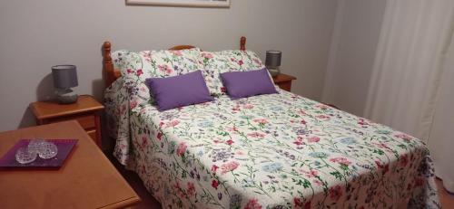 サンタ・クルス・デ・ラ・パルマにあるAvenida El Puente, 26のベッドルーム1室(花柄のベッドカバー、紫色の枕付)