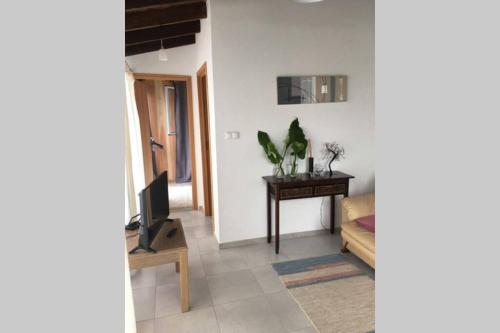 ein Wohnzimmer mit Tisch und Fernseher in der Unterkunft SERMAR 1 in Rabo de Peixe