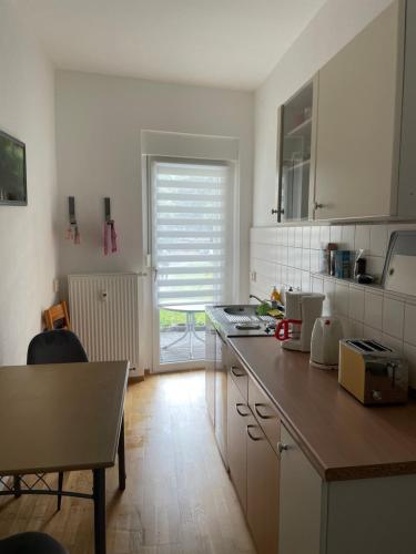 a kitchen with a counter and a table and a window at Cottbus - zentrumsnah in Cottbus