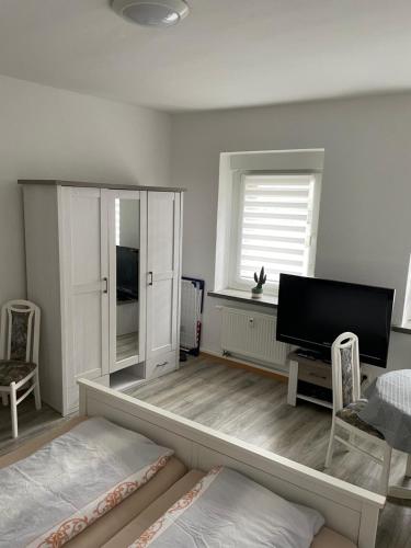 um quarto com uma cama, uma televisão e uma janela em Cottbus - zentrumsnah em Cottbus