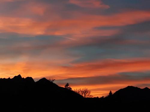 a sunset in the mountains with a red sky at Majerotto in Obsteig