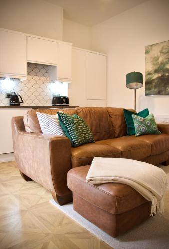 a living room with a brown couch and a kitchen at The Dunes in Redcar