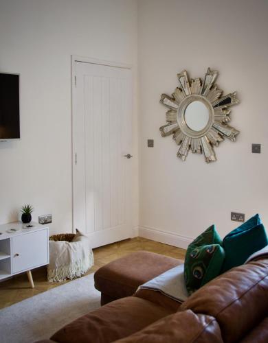 a living room with a couch and a mirror on the wall at The Dunes in Redcar