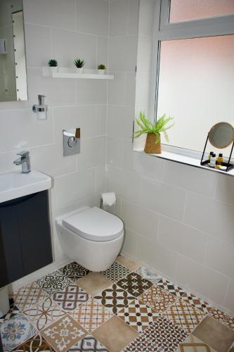 a white bathroom with a toilet and a sink at The Dunes in Redcar