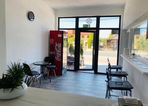 a restaurant with chairs and tables and a door to a store at Four Rooms in Curtea de Argeş